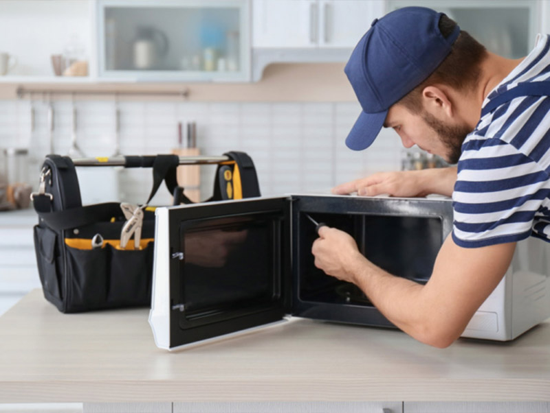 technican is repairing the Oven in the kitchen