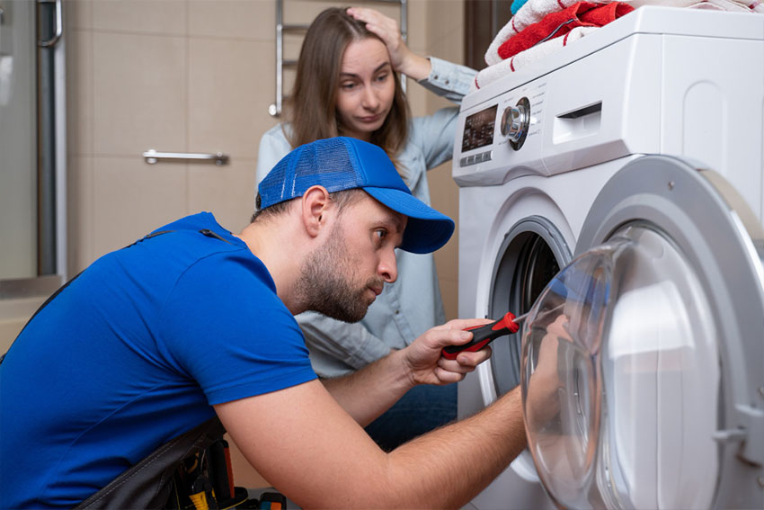 Handyman is fixing a Electrolux washing machine