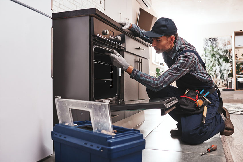 man is repairing SMEG Oven in the kitchen